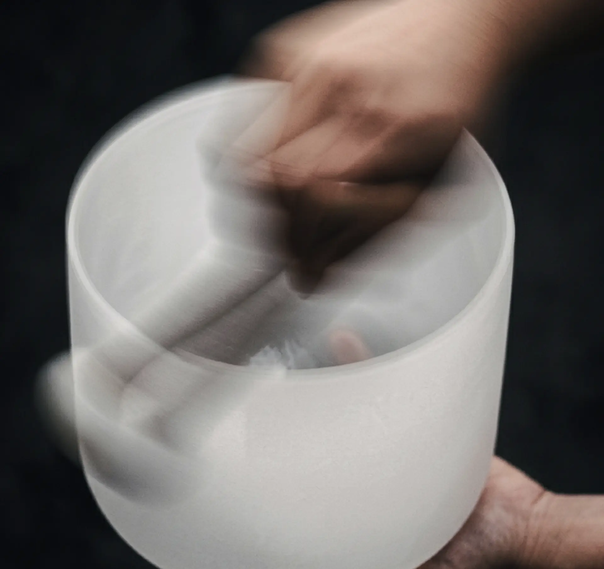 Hand playing a singing bowl for a sound bath
